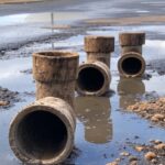 Tubulações de saneamento deterioradas em rua de Brasília, representando falha da Caesb no DF e obras tardias em 2025.