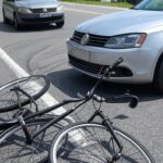 Cena de acidente com bicicleta e VW Jetta em rua de São Sebastião, SP, Brasil.