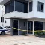 Cena de invasão domiciliar no DF com casa arrombada, fita de isolamento e viaturas policiais, representando crime de tortura e morte.