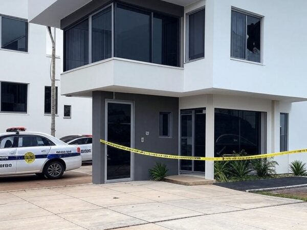 Cena de invasão domiciliar no DF com casa arrombada, fita de isolamento e viaturas policiais, representando crime de tortura e morte.