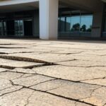 Rampa de acessibilidade quebrada em calçada de Brasília, simbolizando falhas na inclusão para deficientes e TEA no DF.