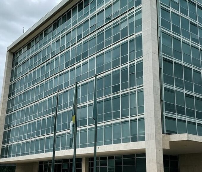 Edifício do TJDFT em Brasília com bandeiras a meio mastro, simbolizando luto pela morte de desembargador.