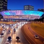 Arena BRB em Brasília com luzes de shows e trânsito congestionado no Distrito Federal.