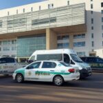 Fachada de hospital em Brasília com viaturas da Polícia Civil investigando mortes por desinfetante na veia.