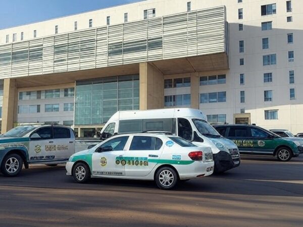 Fachada de hospital em Brasília com viaturas da Polícia Civil investigando mortes por desinfetante na veia.