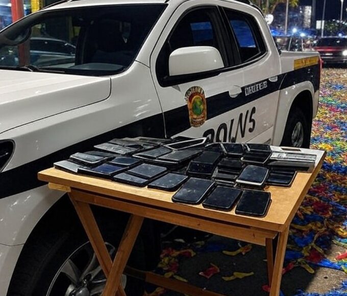 Viatura da polícia no Carnaval de Brasília com celulares furtados recuperados, cena noturna festiva sem pessoas.