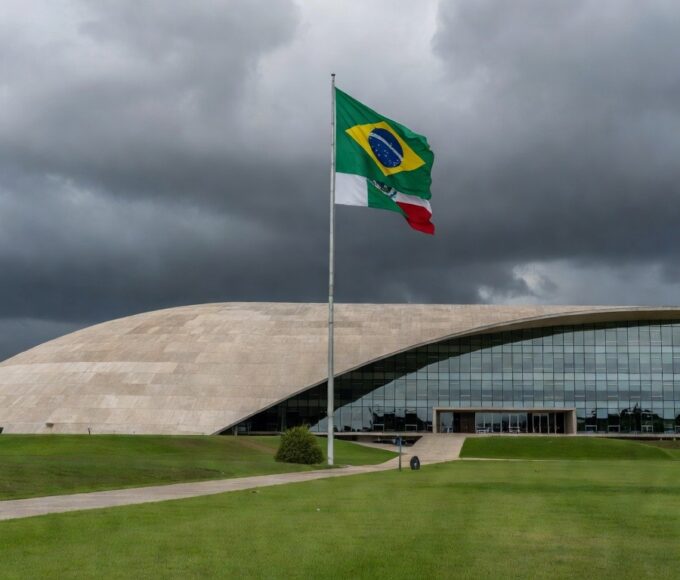 Edifício da CLDF em Brasília com documentos espalhados, representando atraso na regulamentação de lei antissupremacista.