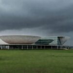Edifício da CLDF em Brasília sob céu nublado, simbolizando críticas por homenagear CRO-DF em meio a prioridades urgentes no DF.