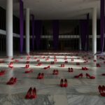 Edifício da CLDF em Brasília com fitas roxas simbolizando luta contra violência a mulheres, em tom negativo.