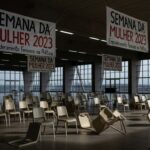 Edifício da CLDF em Brasília com banner da Semana da Mulher, contrastando com desigualdades urbanas no DF.