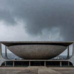 Edifício da Câmara Legislativa do DF sob céu nublado, representando críticas por promessas vazias a mulheres e idosos.