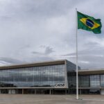 Fachada do prédio da Caesb em Brasília com bandeira a meio mastro, simbolizando luto pela morte do advogado Marcelo Reis.