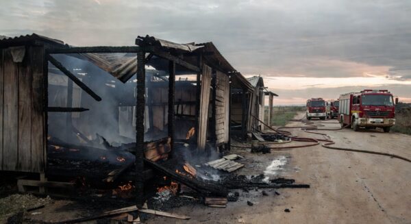 Barraco destruído por incêndio em Ceilândia, com viaturas de bombeiros controlando as chamas.