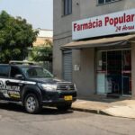 Viatura da PM do DF em frente a farmácia em Planaltina, cena de operação policial contra furto.
