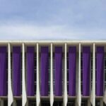 Edifício governamental em Brasília com faixas roxas representando programas contra violência doméstica da Sejus-DF.
