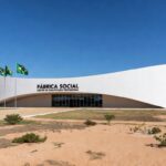 Prédio moderno em Brasília representando a Fábrica Social, com arquitetura icônica e bandeiras do Brasil.