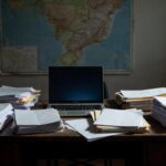 Mesa de redação com laptop e documentos em branco simbolizando falta de dados factuais para reportagem