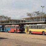 Estação de ônibus no DF com veículos desgastados representando falhas no transporte público