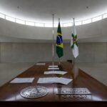 Plenário da CLDF com documentos e emblemas de conselhos profissionais em Brasília