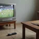 Sala de estar brasileira com TV de futebol e faca, representando caso de agressão no DF