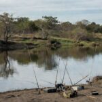 Rio no DF com equipamentos de pesca esportiva abandonados, simbolizando aprovação sem investimentos