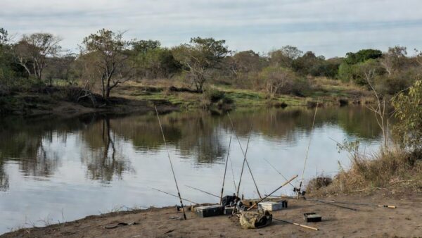 Rio no DF com equipamentos de pesca esportiva abandonados, simbolizando aprovação sem investimentos