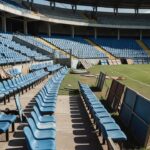 Setor do Estádio Bezerrão com cadeiras desalinhadas e barreiras danificadas após confusão entre torcedores.
