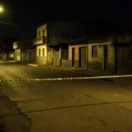 Rua vazia em Goiás com fita de isolamento policial em cena noturna